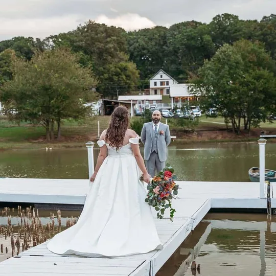 A bride crossing the Floating Dock over the pond on her way to the ceremony near Knoxville