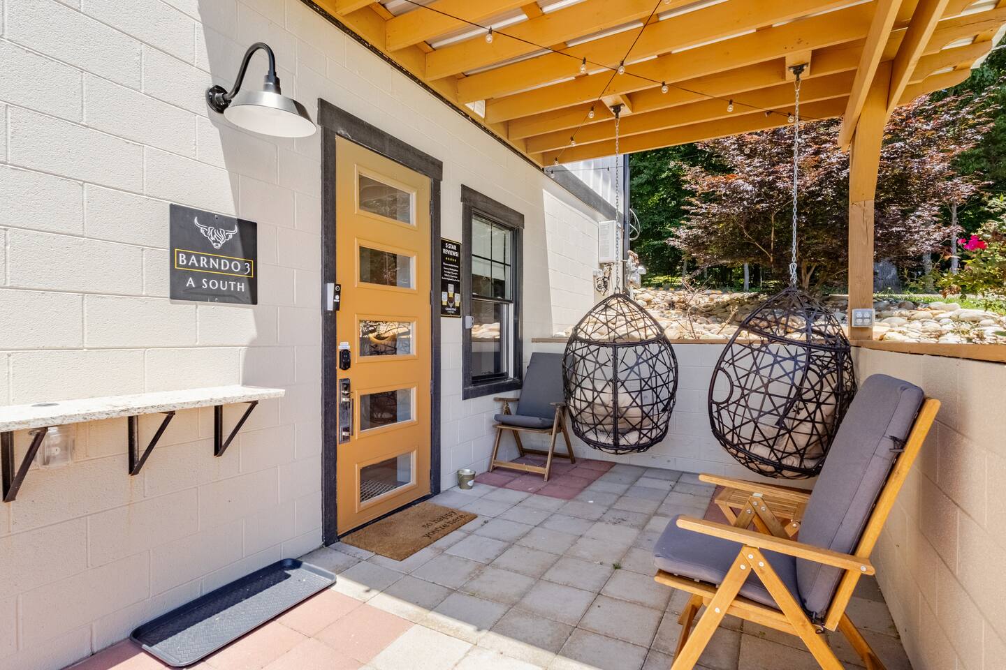 Covered patio with hanging egg chairs and a cozy private outdoor seating area